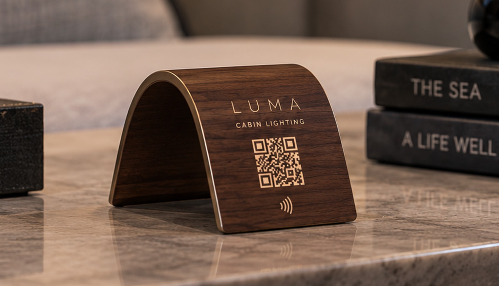 Concept render: a curved walnut table plaque with brass QR and NFC marks